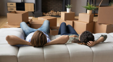 Couple relax on couch at new home at moving day
